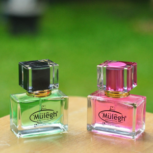 botol pink dan hijau dengan latar belakang taman hijau blur