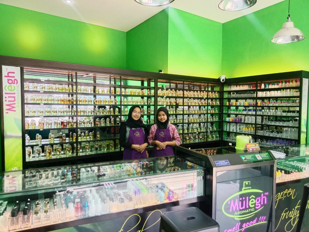 dua petugas gerai mulegh berdampingan latar belakang etalase parfum